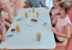 dzieci jedzą babeczki i pija soczki